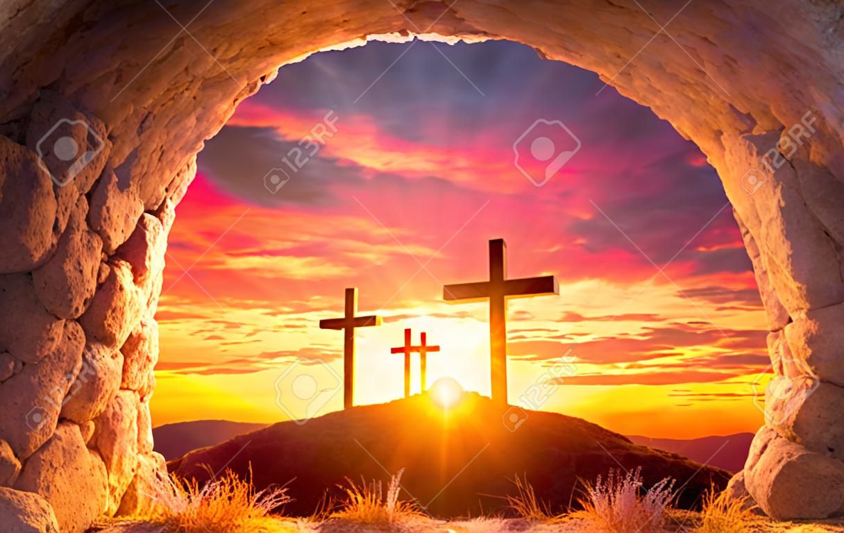 Koncepcja zmartwychwstania - pusty grób z trzema krzyżami na wzgórzu o wschodzie słońca