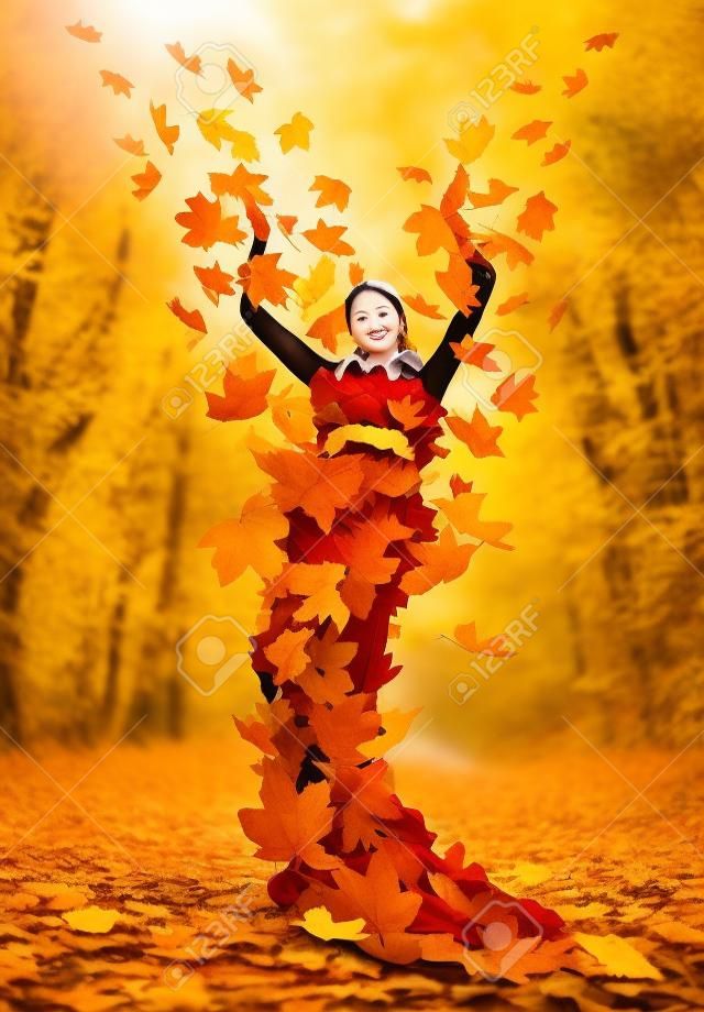 Piękna jesień pani w sukience z żółtych liści klonu