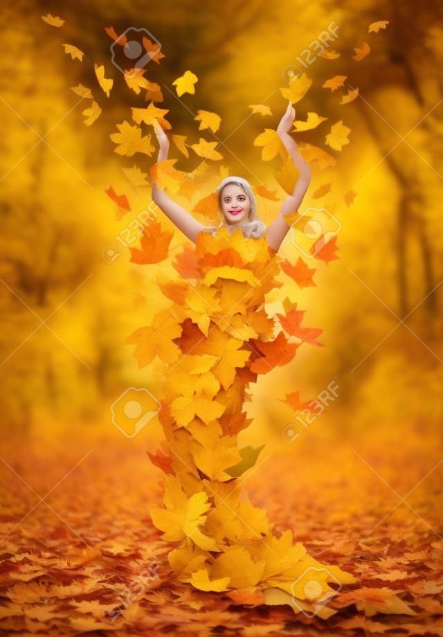 Piękna jesień pani w sukience z żółtych liści klonu