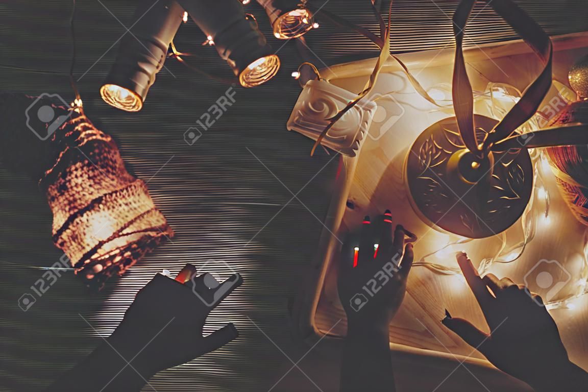 Weihnachtskonzept. Retro- Birnenlichter und hölzernes Baumspielzeug auf Draufsicht des rustikalen hölzernen Hintergrundes in der Nacht. saisonale Grußkarte. Platz für Text. stimmungsvolles Winterbild