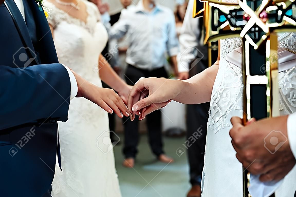 bruiloft ceremonie van stijlvolle elegante bruid en bruidegom in de kerk, uitwisseling trouwringen