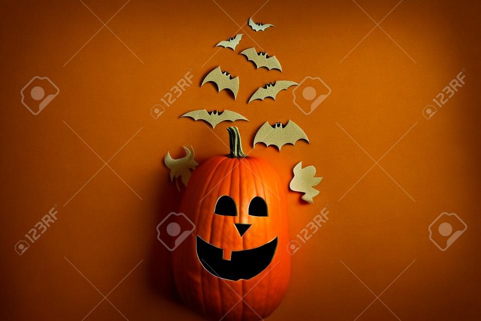 Halloween flat lay. Lanterna de macaco de abóbora e morcegos pretos, fantasmas, decorações de papel de aranha no amarelo