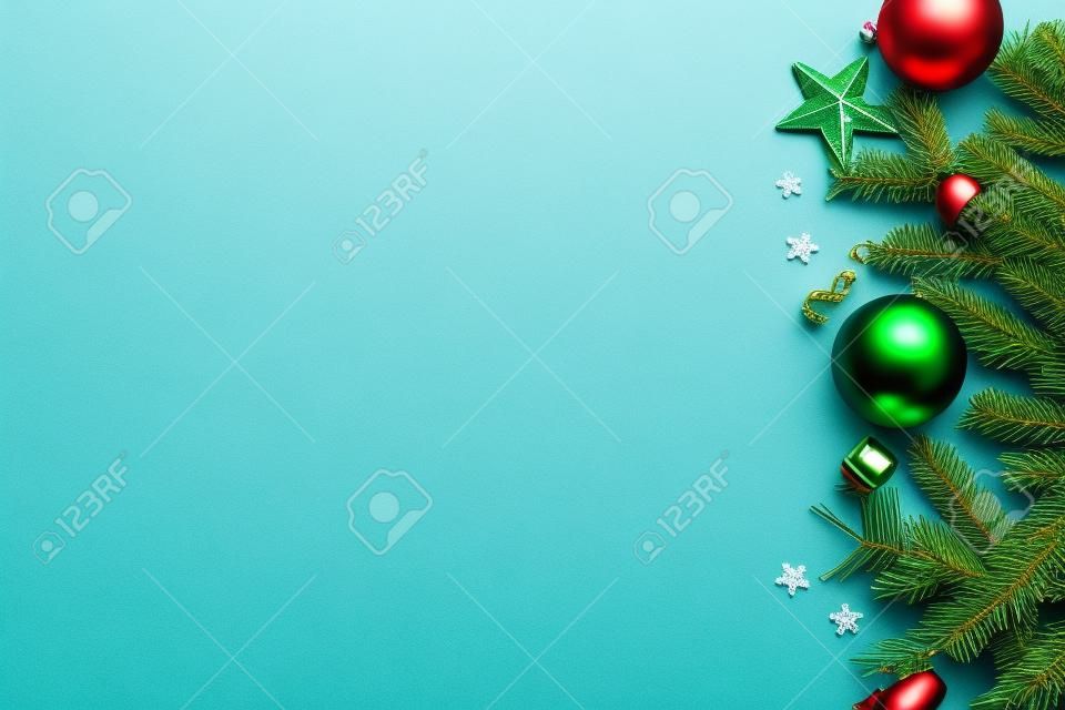Merry Christmas! Stylish christmas border with festive decorations, confetti, fir branches on green background flat lay. Christmas banner. Seasons greetings card template, space for text