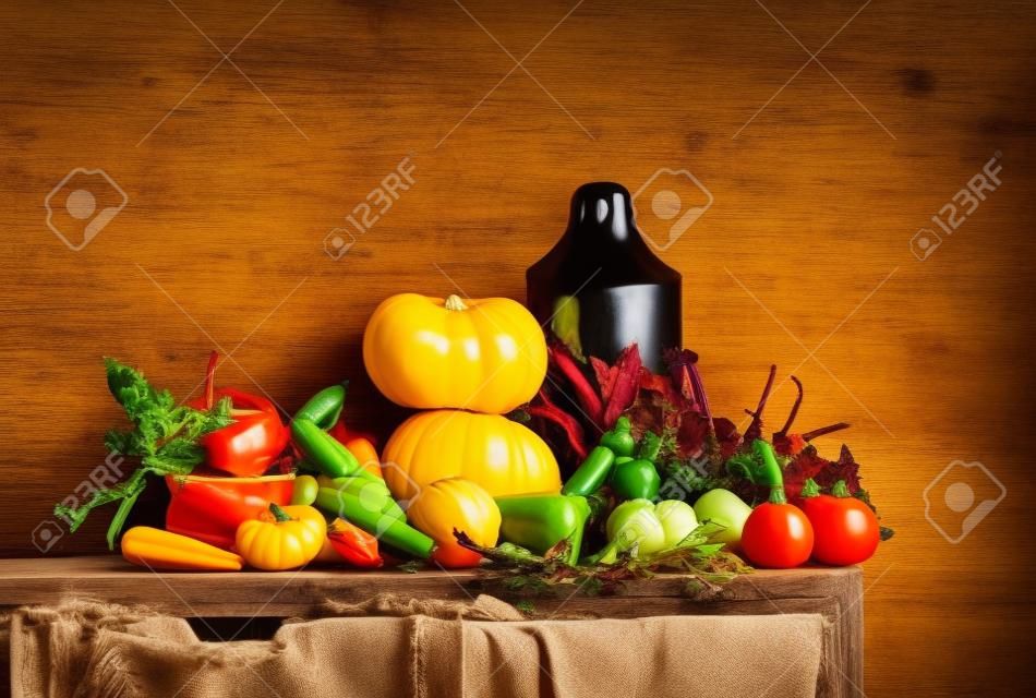 Fall seasonal vegetarian food ingredients variety. Assortment of Autumn vegetables for healthy cooking over rustic kitchen cupboard, white wall background, copy space. Local market organic produce