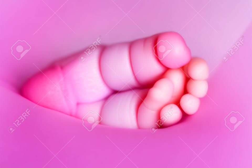 kleine babyvoet met kleine roze vingers close-up