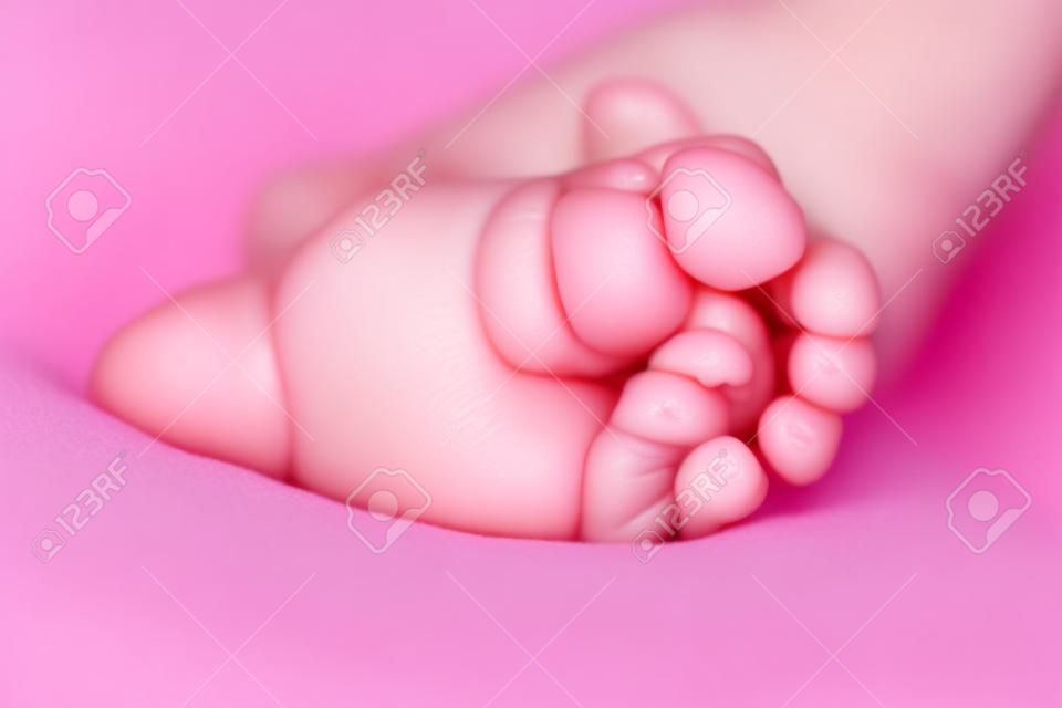 kleine babyvoet met kleine roze vingers close-up