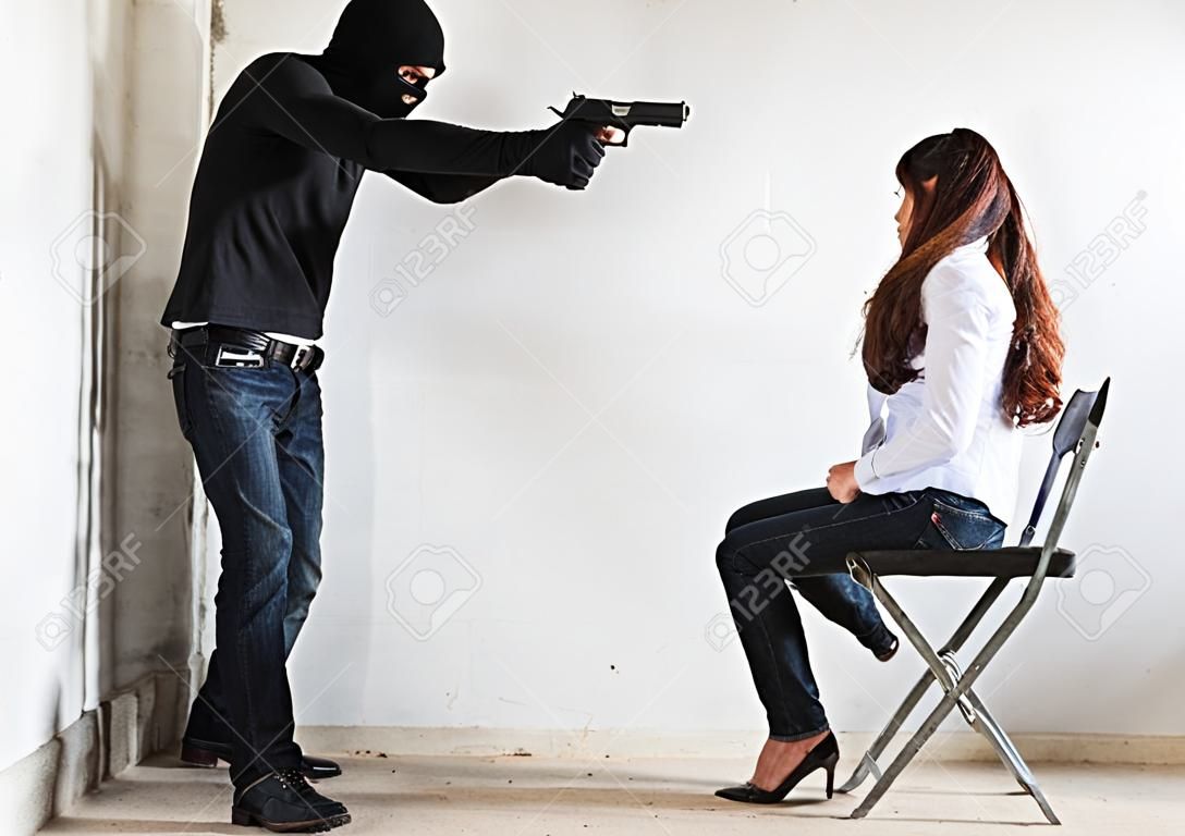 El ladrón ladrón apunta con la pistola a la cabeza está a punto de matar a la mujer rehén, crimen