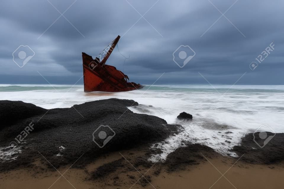 Une vieille épave ou un bateau abandonné se tient sur la plage