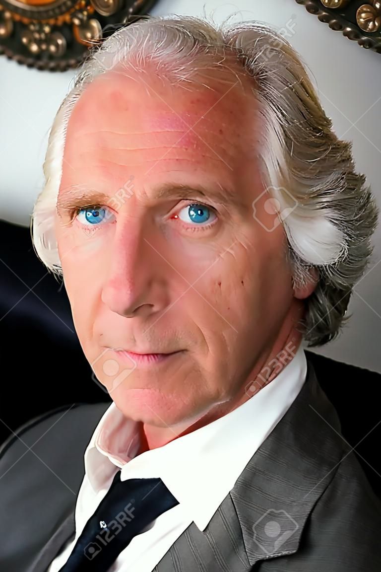 three quarter face portrait of handsome professional blue eyed older man.