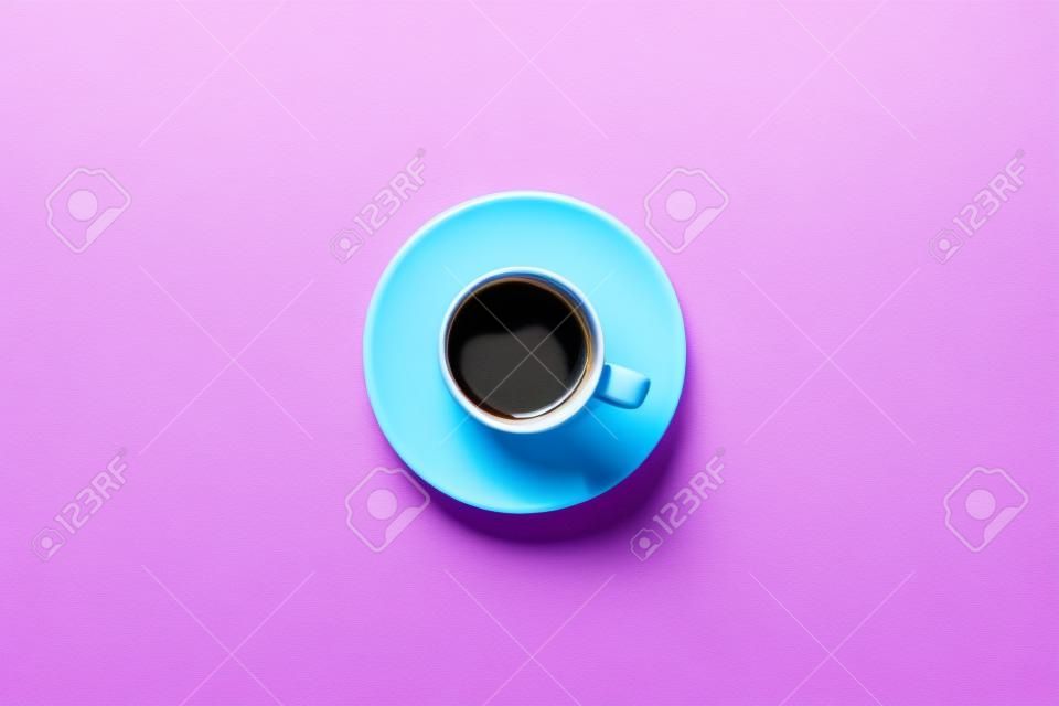 Blaue Tasse Kaffee auf einem bunten rosa Hintergrund. draufsicht mit kopierraum. Morgenkonzept.