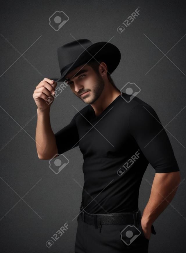 bel homme portant un chapeau noir sur un fond texturé fumé