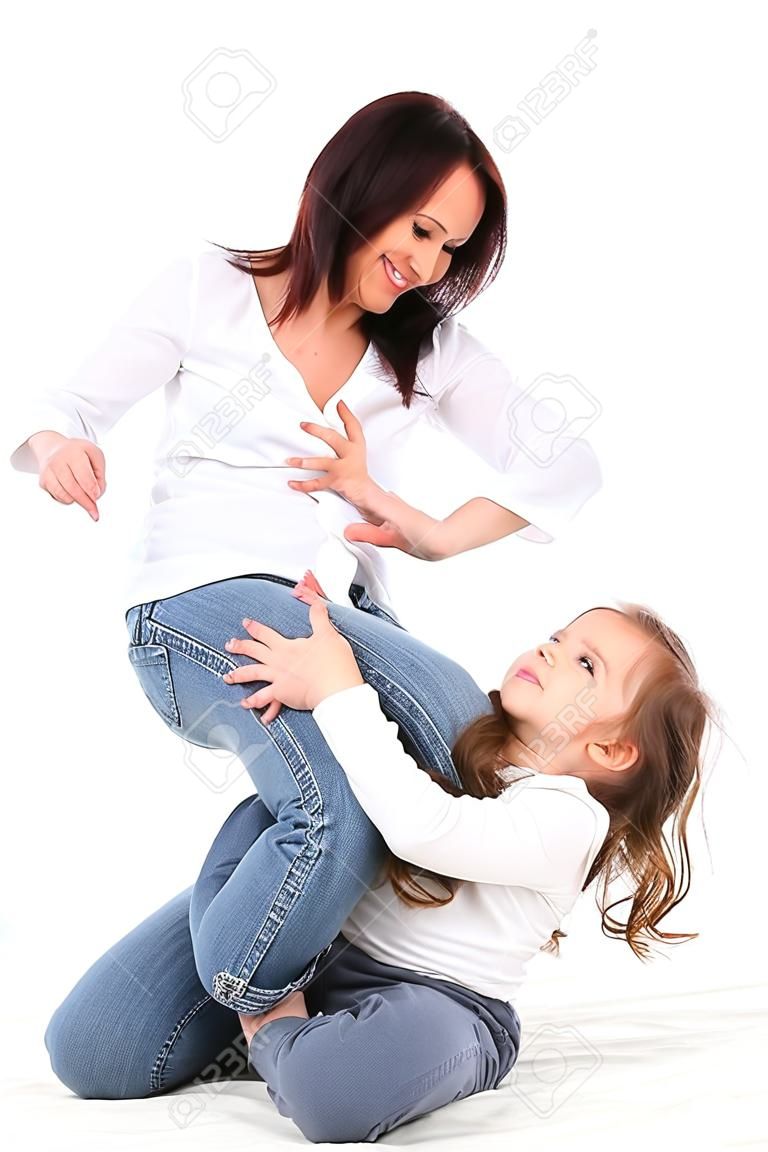 mother tickling her toddler girl