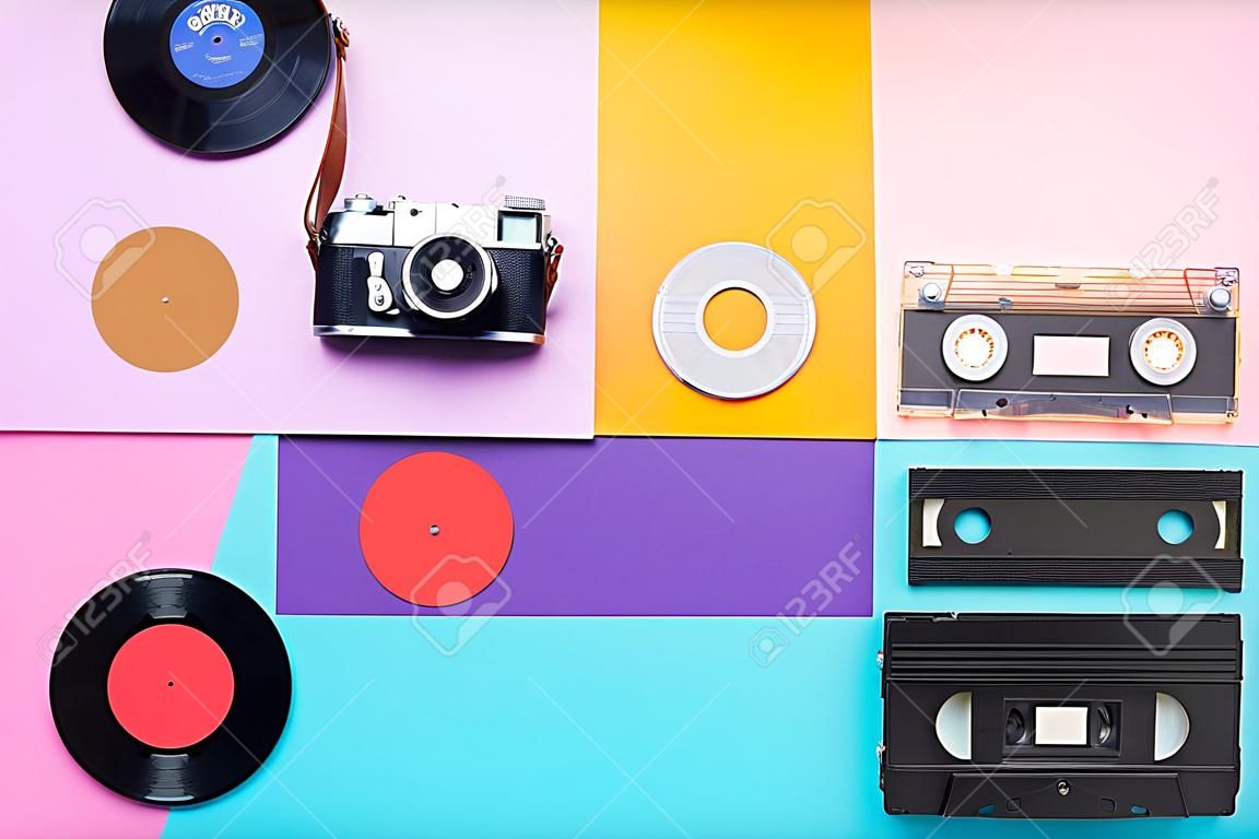 Retro top view still life. Vinyl record, vintage film camera, video and audio cassette on blue background. Flat lay. Pop art