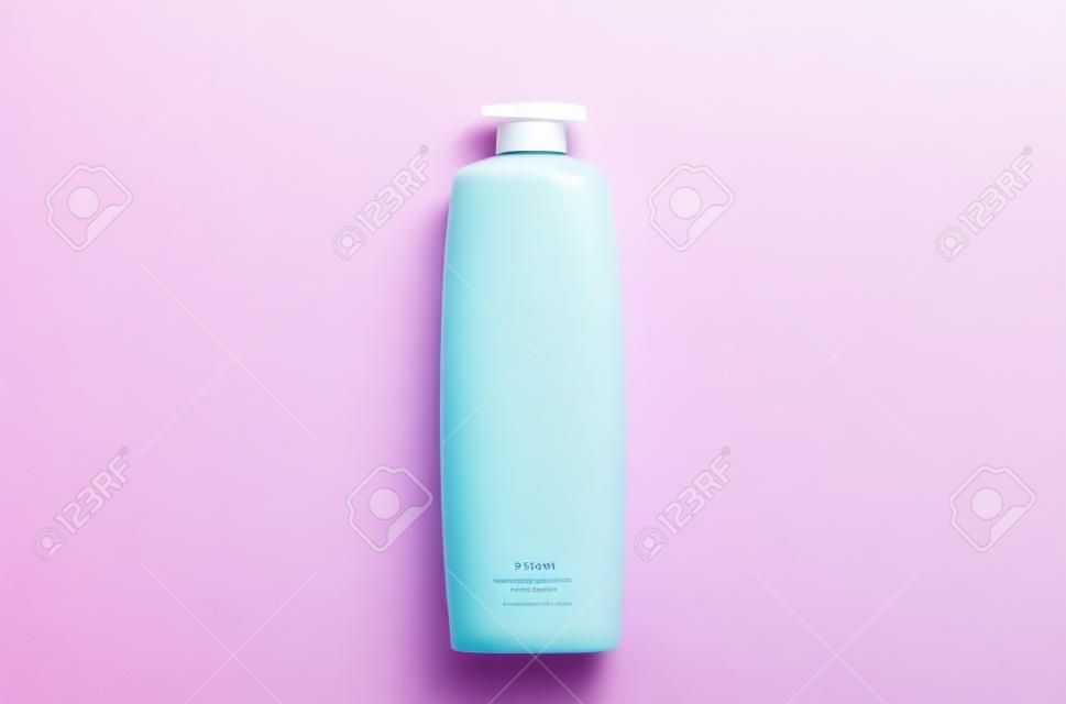 Shampoo bottle on pink blue pastel background. Hair care. Hygiene and cosmetics. Beauty flat lay. Top view