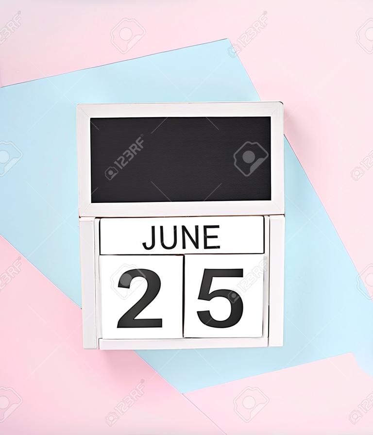White wooden calendar with the date june 25 on a blue pink background. top view