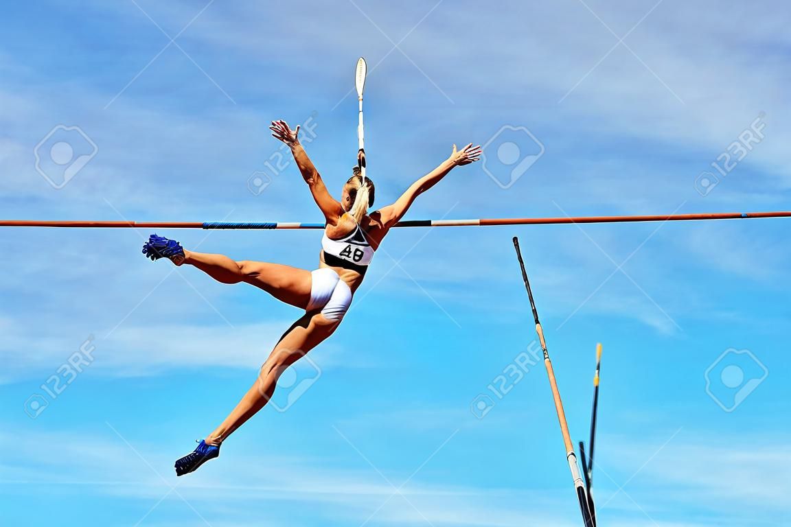 pole vault woman vaulter successful attempt to fly background in blue sky