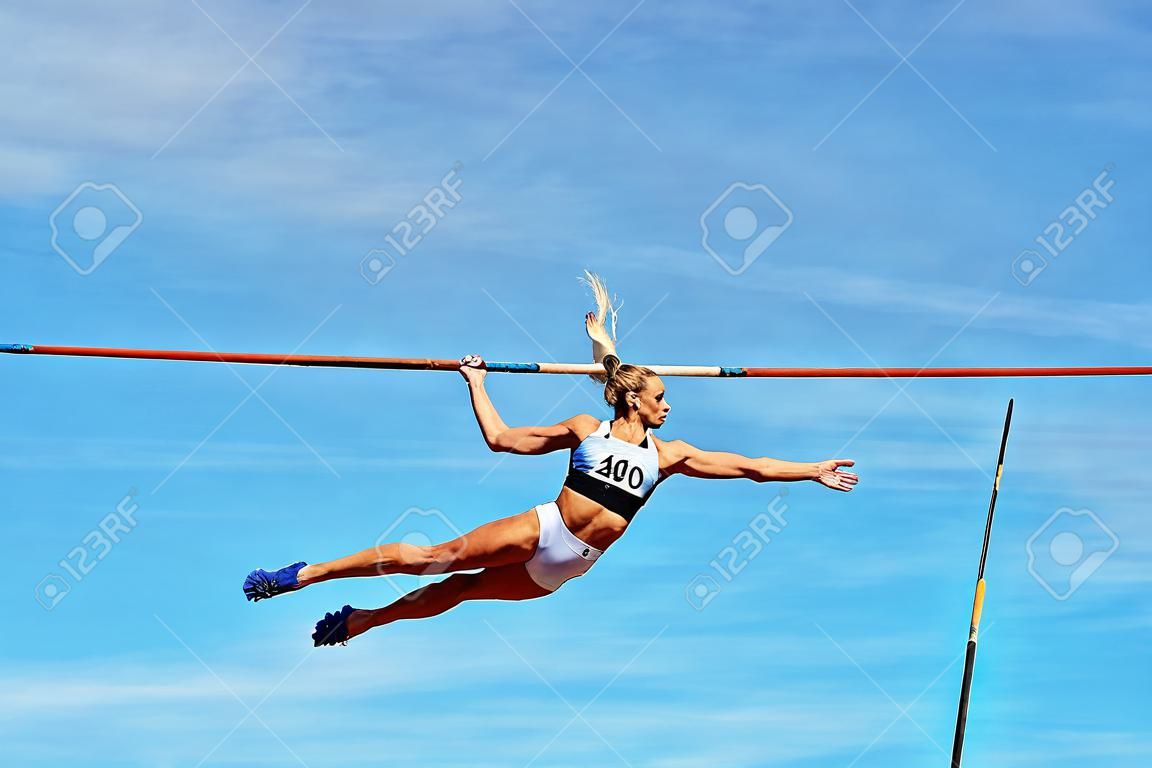 pole vault woman vaulter successful attempt to fly background in blue sky
