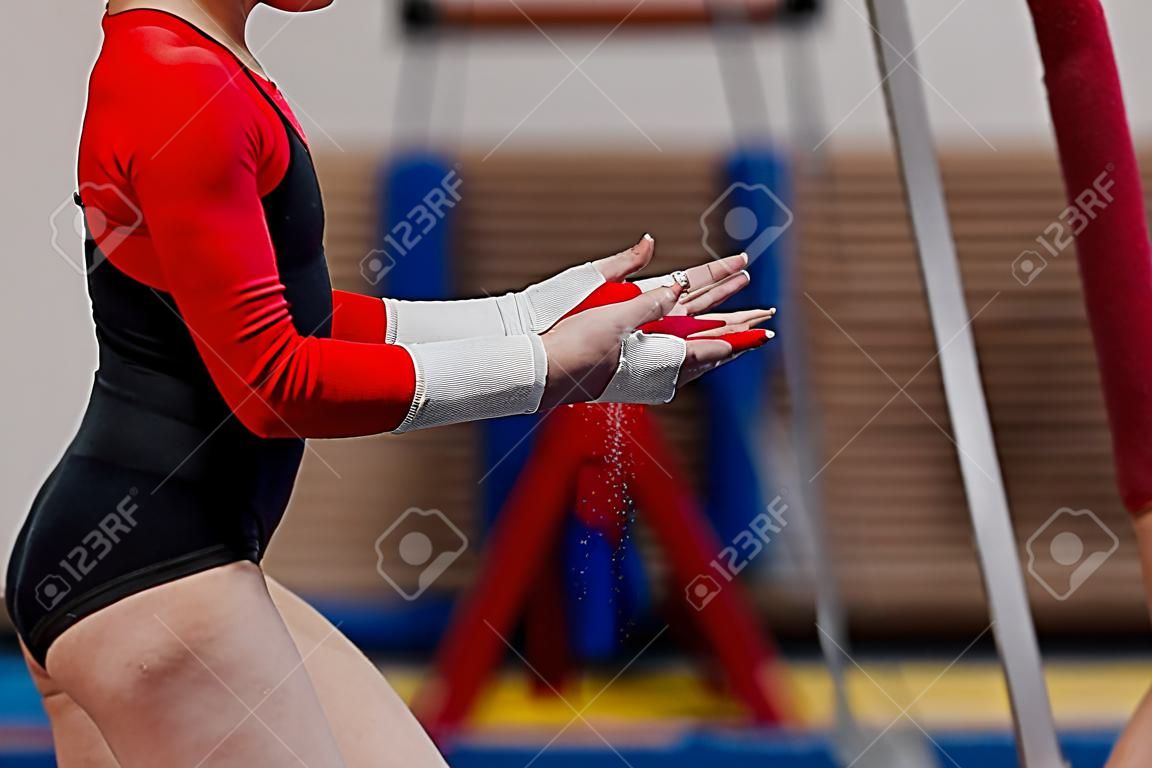 girl gymnast in gymnastics hand grips and gym chalk