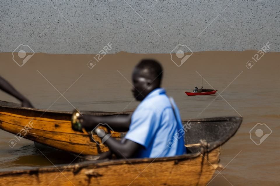 African men sitting in the boat. Males working, fishing. Business of local people in Africa.