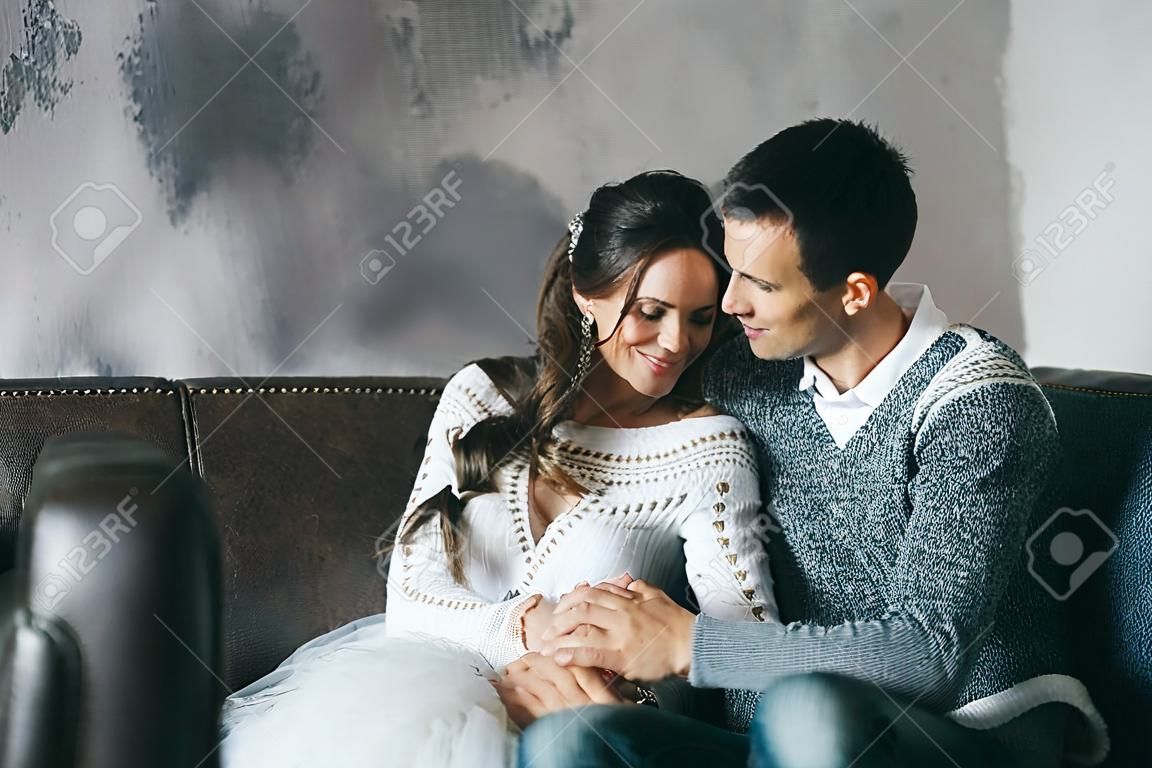Newlyweds couple are chilling at home on the sofa. Copy space