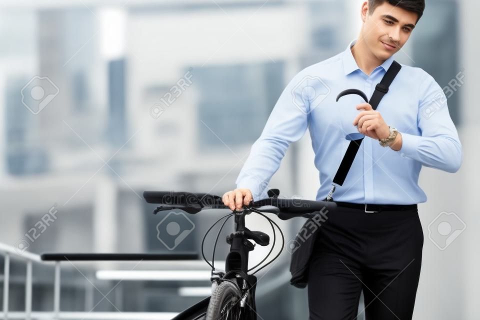 仕事は待たない。黒い自転車でフォーマルな服を着たビジネスマンが市内にいます。