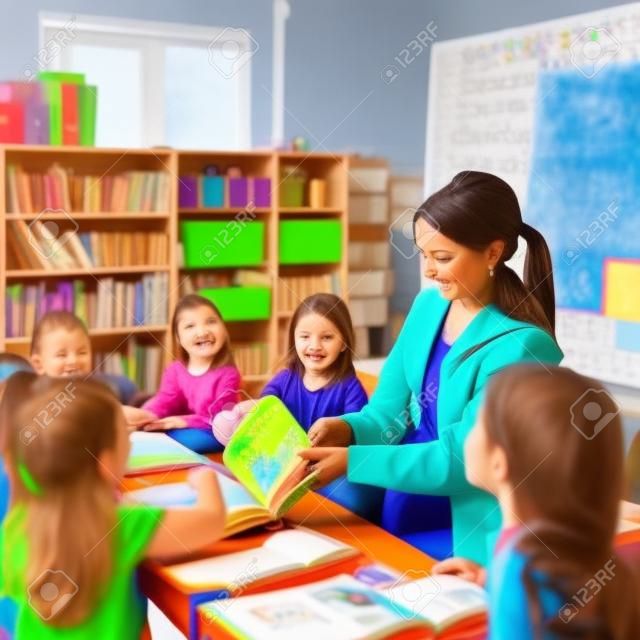 A female teacher reading a book to children in a classroom. AI generative image.