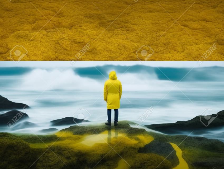 Una persona con un impermeabile giallo in piedi sulle rocce di fronte all'oceano. ai immagine generativa.
