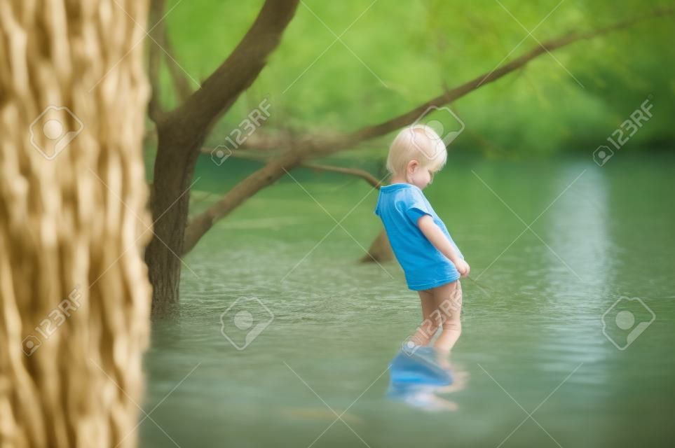 blondes Kind pinkelt in den See