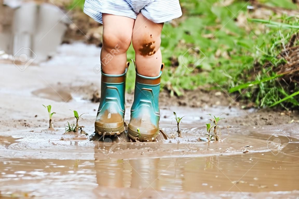 Child's feet stomping in a mud puddle. 