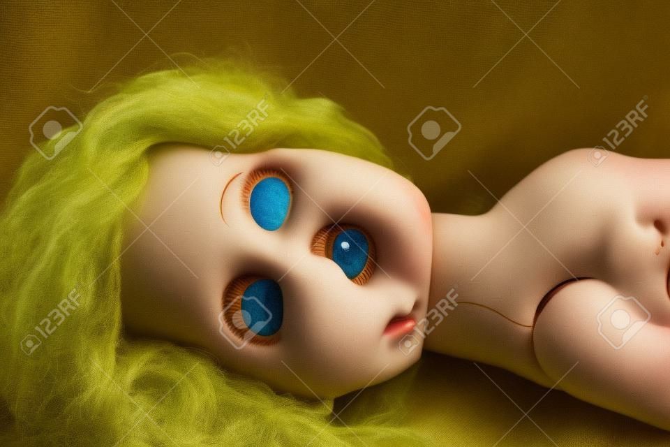 An old antique doll with one eye closed