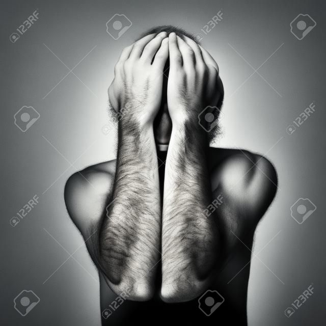 Homme triste couvre son visage avec les mains et pleurer de désespoir.