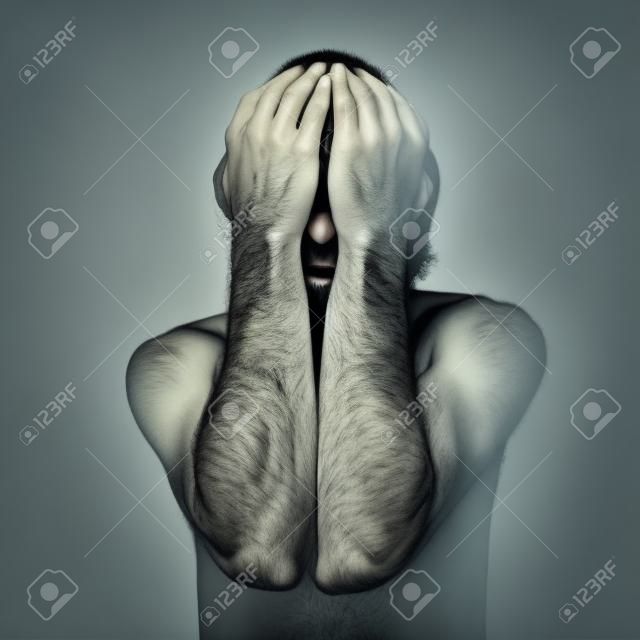Homme triste couvre son visage avec les mains et pleurer de désespoir.