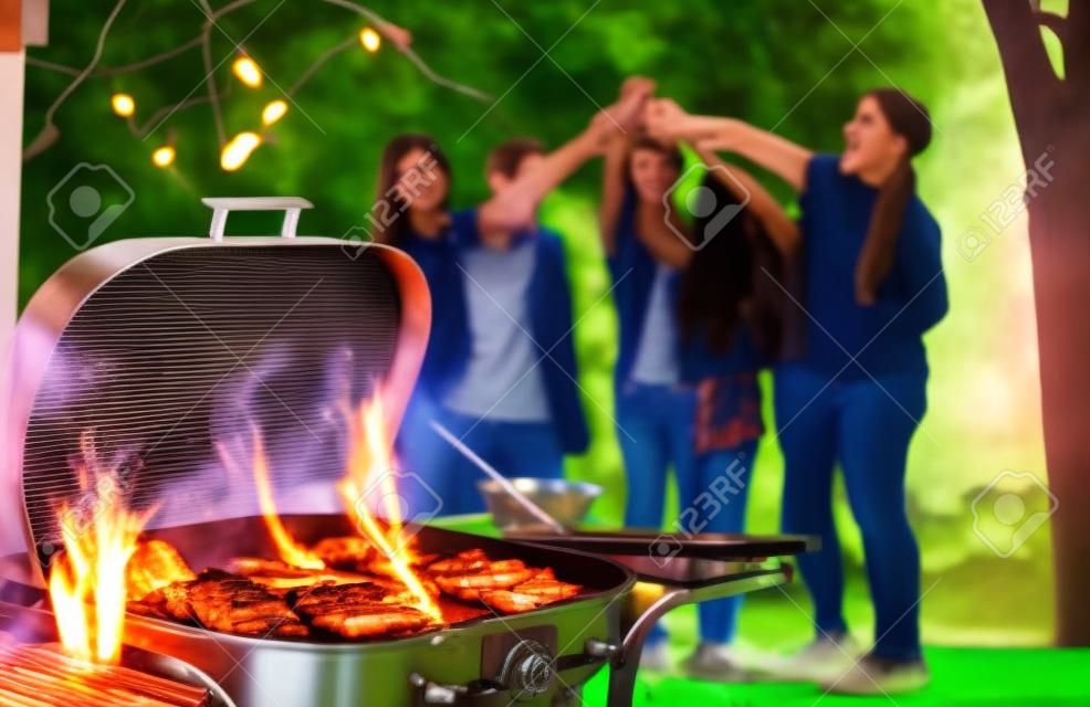 Grupa sześciu nastolatków bawiących się na przyjęciu przy grillu