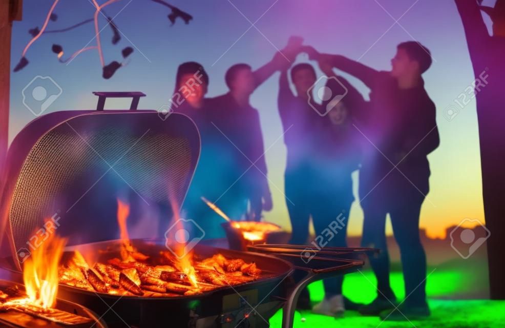 Grupa sześciu nastolatków bawiących się na przyjęciu przy grillu