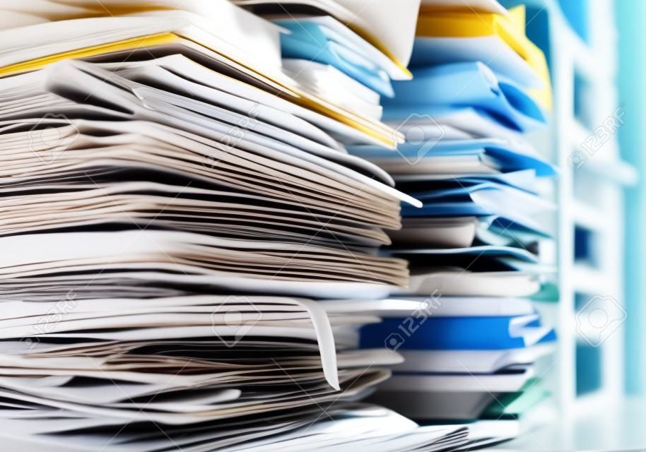 Pilhas de papelada e arquivos no escritório: sobrecarga de trabalho, gerenciamento de arquivos e conceito de administração