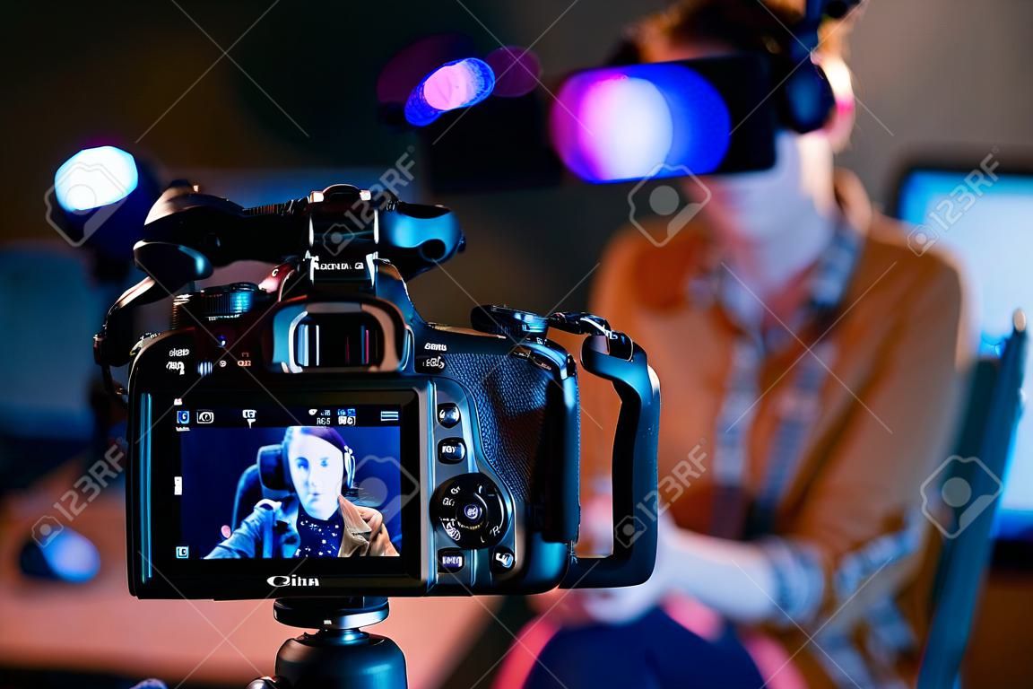Jovem vlogger gravando um vídeo em seu estúdio, câmera profissional em primeiro plano