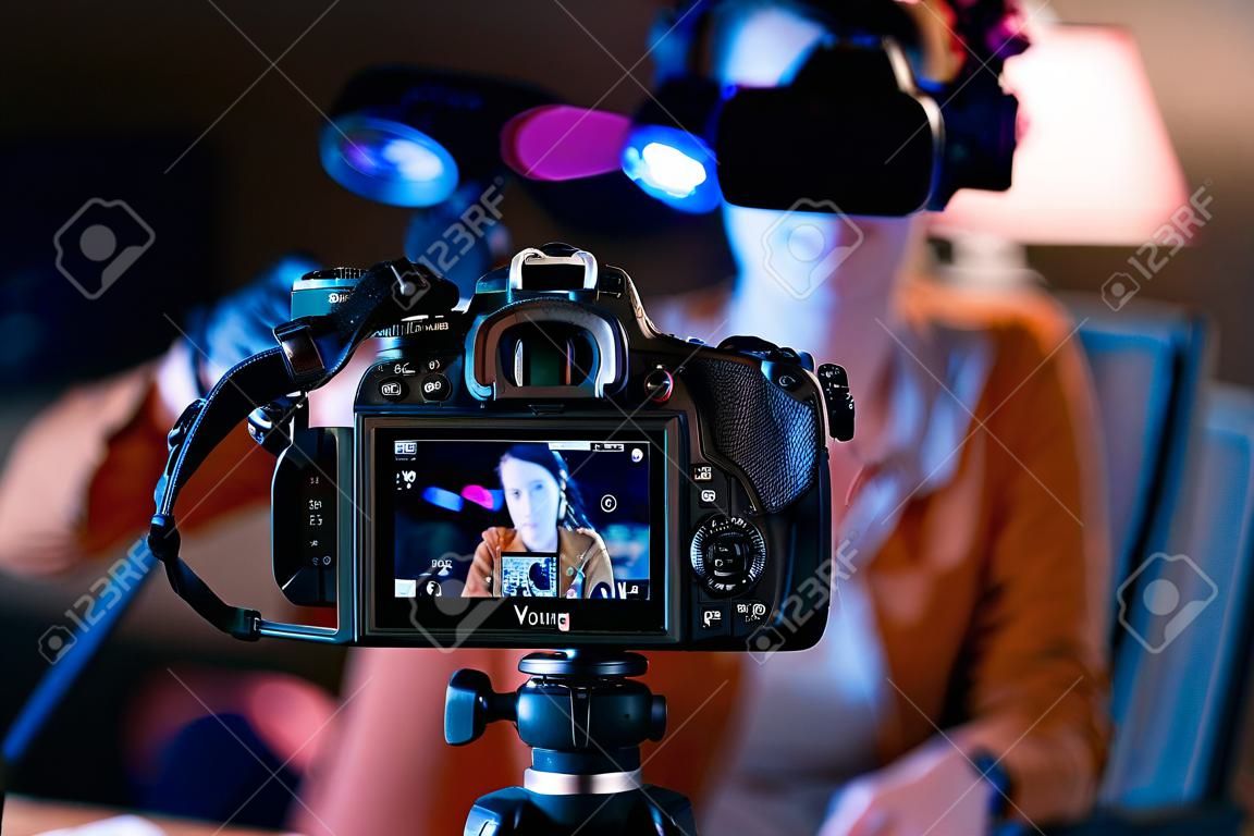 Giovane vlogger che registra un video nel suo studio, telecamera professionale in primo piano