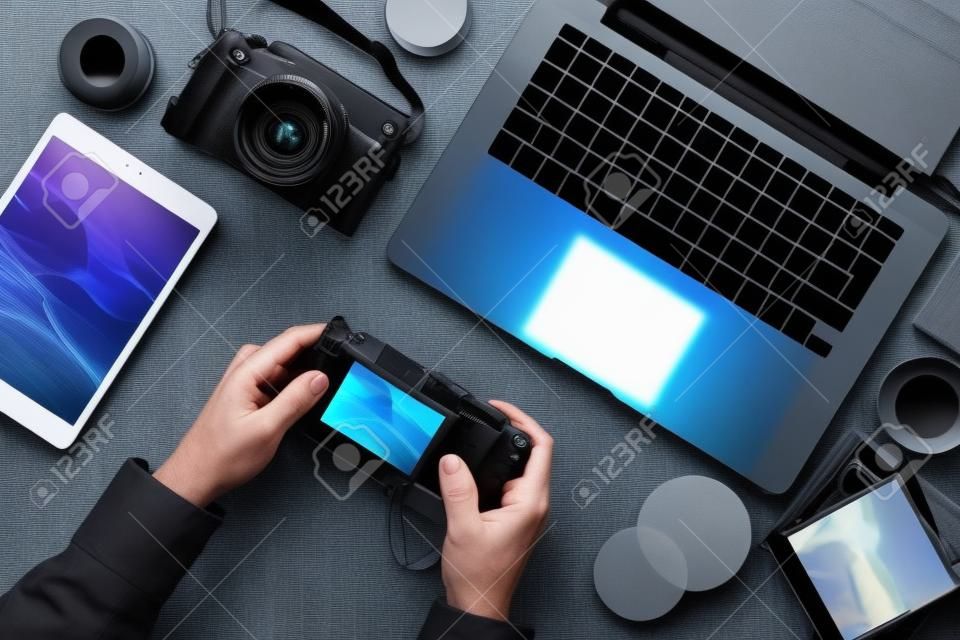 Professionelle fotoausrüstung, tablet und laptop auf einem desktop, ein fotograf überprüft vorschaubilder auf dem kameradisplay