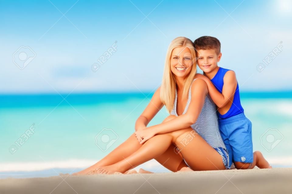 Mother And Son Relaxing Together On Beach Holiday