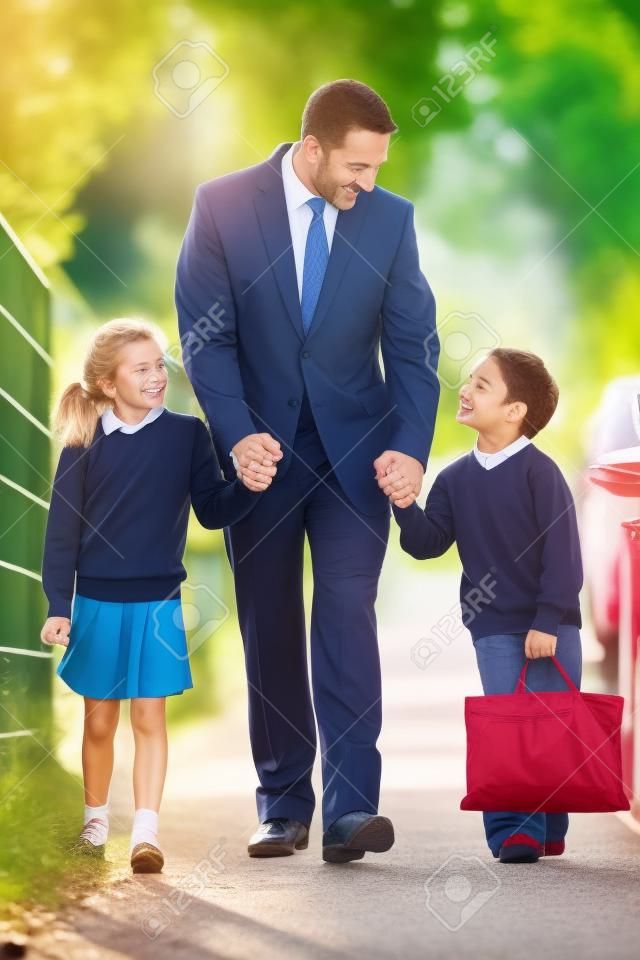 Vater zu Fuß zur Schule mit Kindern auf dem Weg zur Arbeit