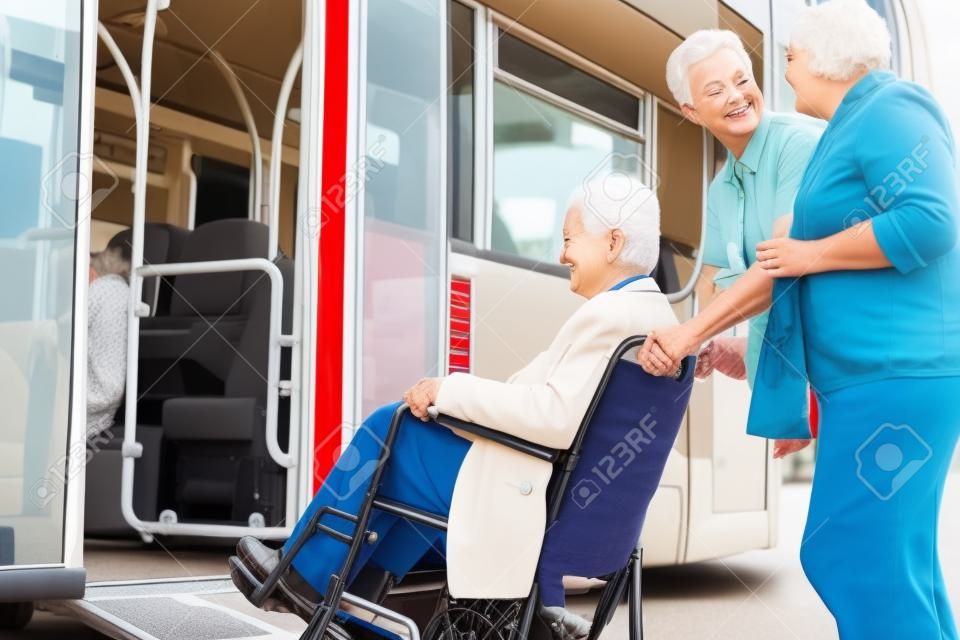 Conductor Ayudar a los pares mayores Junta autobús por la rampa para sillas de ruedas