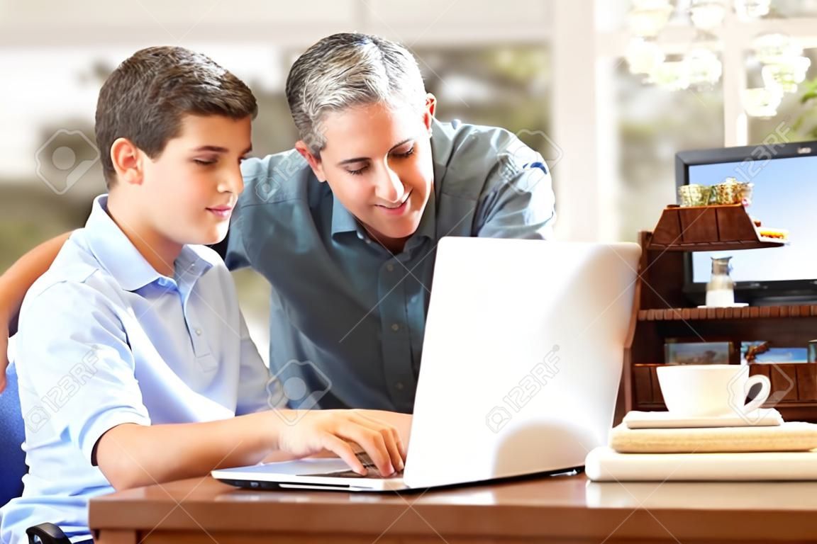 Vader en tiener zoon kijken naar Laptop samen