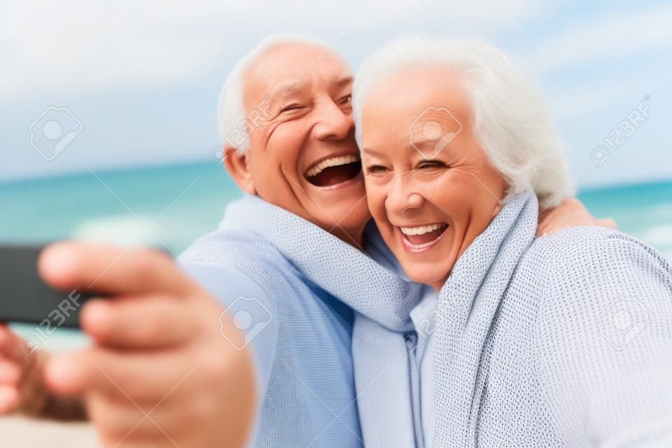 老年夫妇站在海滩采取selfie