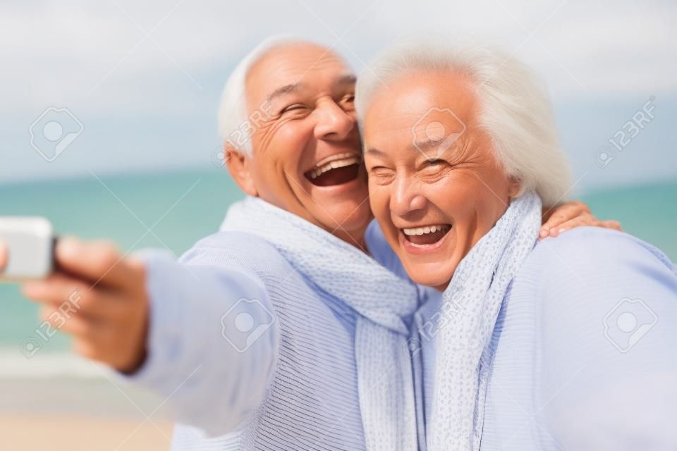 老年夫妇站在海滩采取selfie