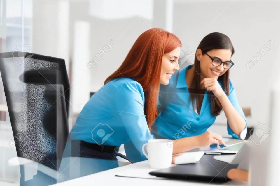 Mulheres que trabalham junto, interior do escritório
