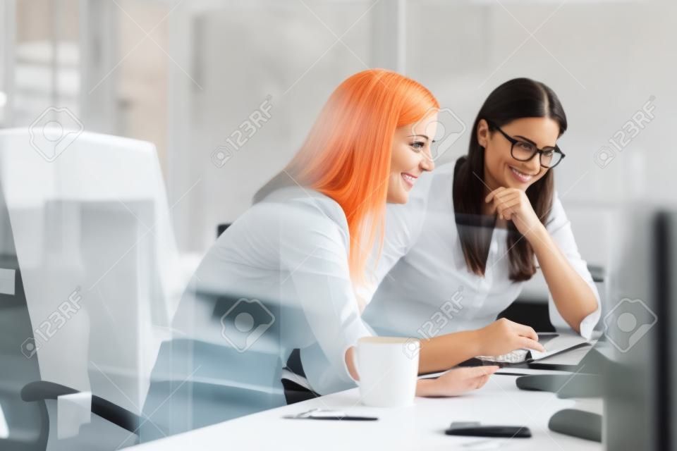 Mulheres que trabalham junto, interior do escritório