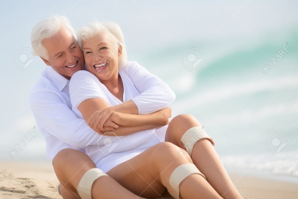 資深夫婦坐在海灘一起