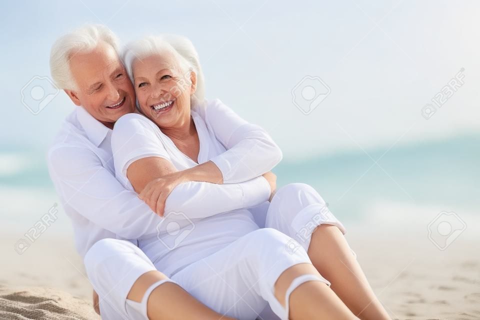 高级夫妇一起坐在沙滩上