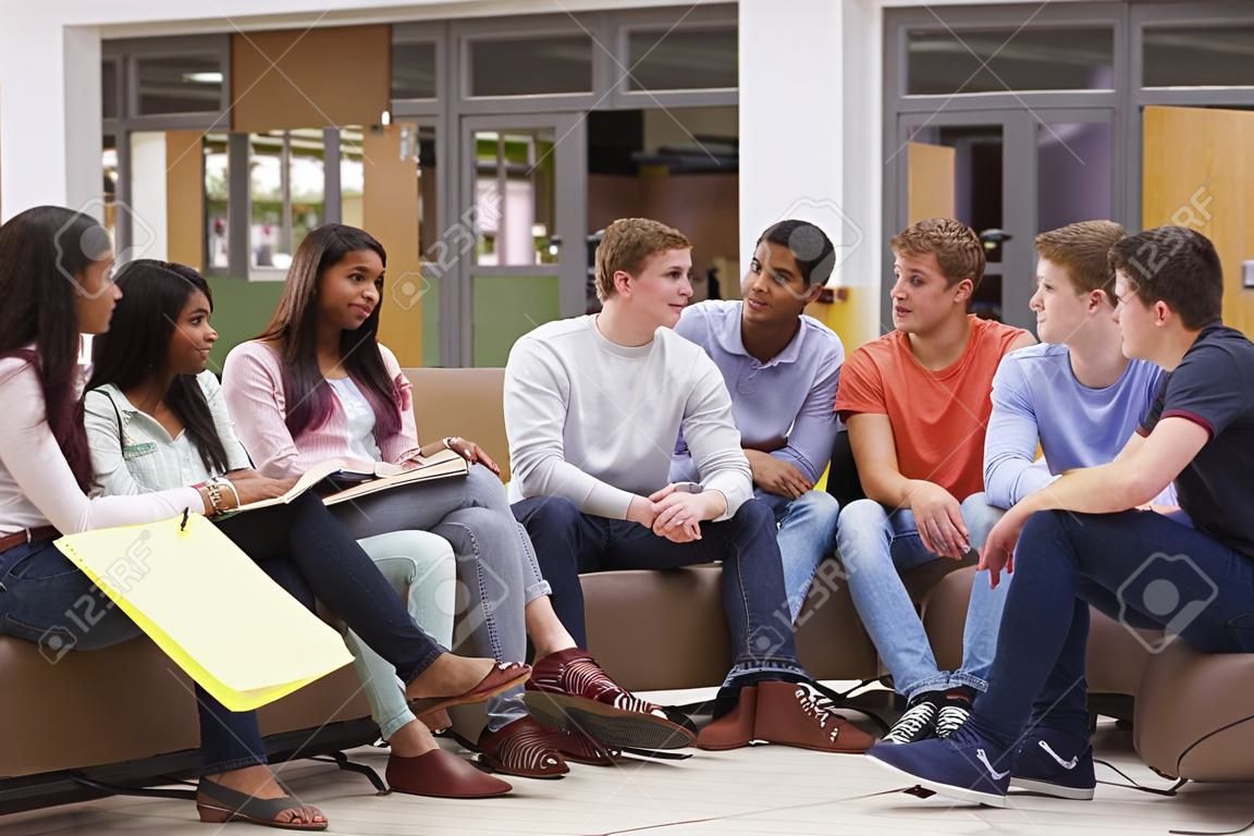 Grupo de estudiantes universitarios sentados y hablando juntos