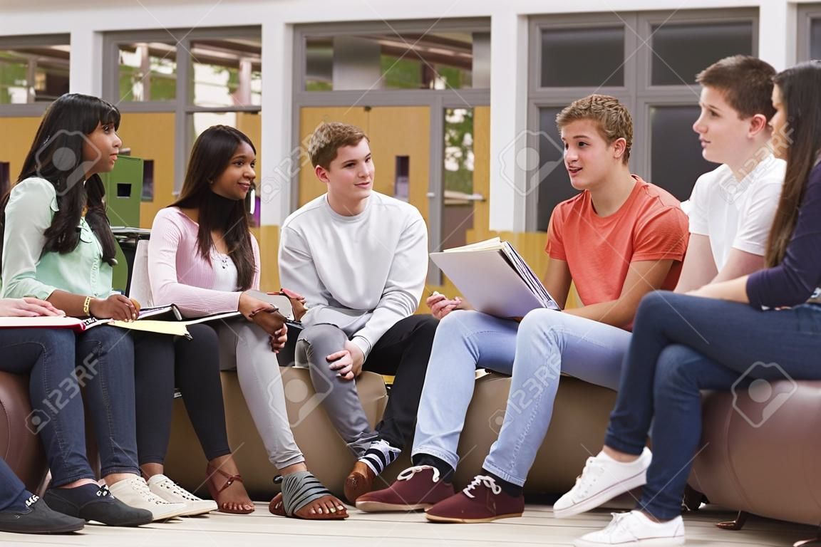 Grupo de estudiantes universitarios sentados y hablando juntos